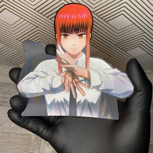 May include: A white button-down shirt with a black tie. The shirt has a holographic effect and the character from the anime "Food Wars!" is wearing it. The character has red hair and brown eyes.