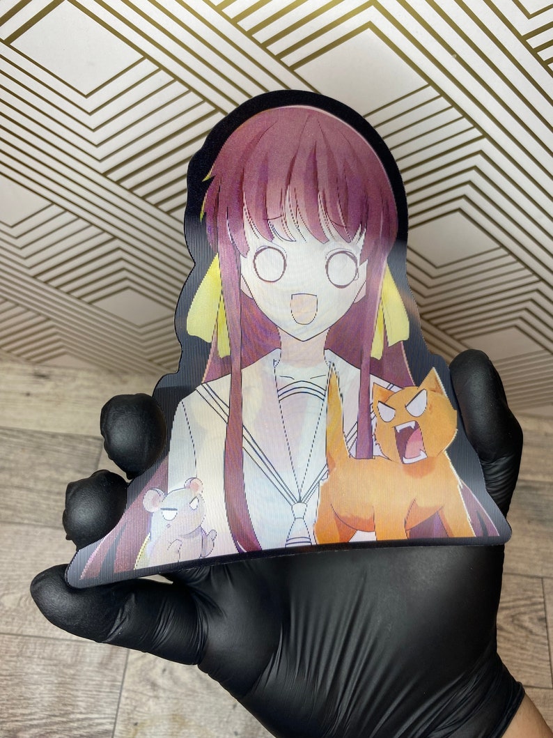 Puede incluir: Un recorte de un personaje de anime con cabello largo morado y cintas amarillas. El personaje lleva un uniforme de marinero blanco con un cuello azul y una corbata de lazo roja. El personaje sonr&iacute;e y tiene ojos grandes y blancos. El personaje sostiene un peque&ntilde;o oso marr&oacute;n y un gato naranja grande con una melena amarilla. El gato est&aacute; rugiendo.