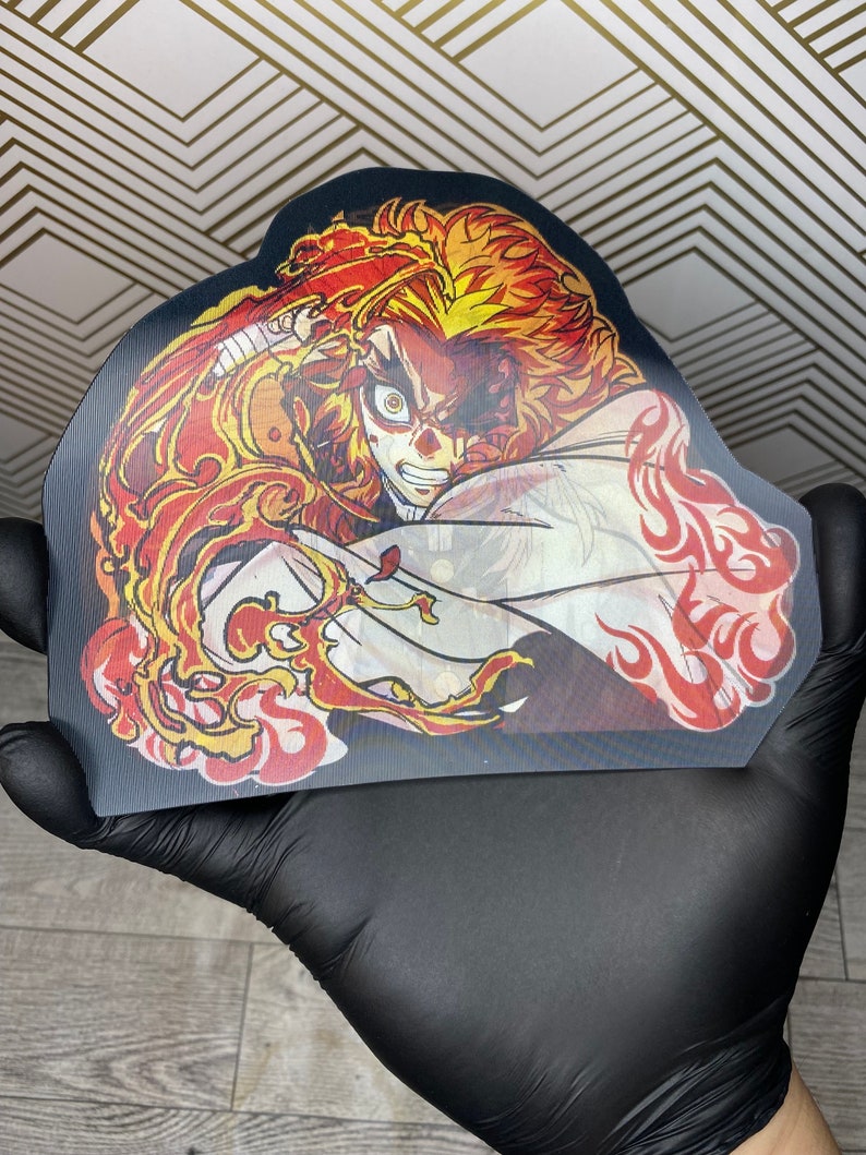 Pu&ograve; includere: Un personaggio anime nero e rosso con capelli arancioni fiammeggianti e una veste bianca. Il personaggio &egrave; raffigurato in una posa dinamica con fiamme che lo circondano.