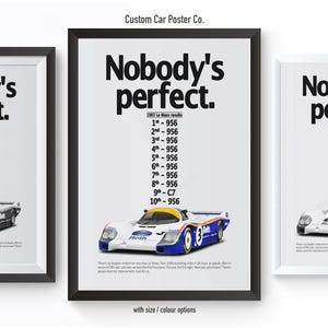 May include: Three black framed posters with white backgrounds and the text "Nobody's perfect." in bold black font. Each poster features a white and blue race car with a black number 956 on the side. The middle poster includes a list of race results for the car.