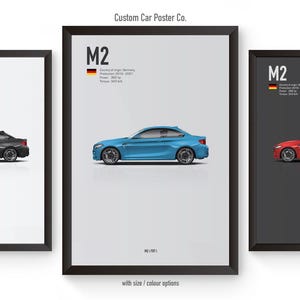 May include: Three framed posters featuring a black, blue, and red BMW M2 car. Each poster has the text "M2" and a German flag in the top left corner. The posters are on a white background.