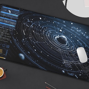 Op de afbeelding: Een groot, rechthoekig muismat met een gedetailleerde blauw-witte afbeelding van een planetenstelsel. Het ontwerp omvat planeten, ringen en hemelse elementen. Een witte computermuis ligt op de mat, naast een laptop en een kleine potplant.