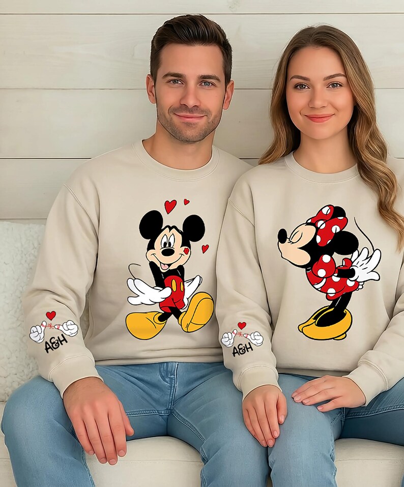 This matching couples top features a playful Mickey-style character and a sweet Minnie-inspired pose, making it the perfect gift for Valentine’s Day or any romantic occasion. Soft, comfortable, and available as a shirt, sweatshirt, or hoodie, it makes a fun outfit for photos, vacations, date nights, and cozy days at home. Personalize the sleeve initials to create a meaningful and unique piece for your partner.