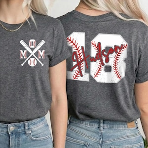 A woman wearing a gray t-shirt with a baseball design and the number 18 on the back, smiling at the camera.