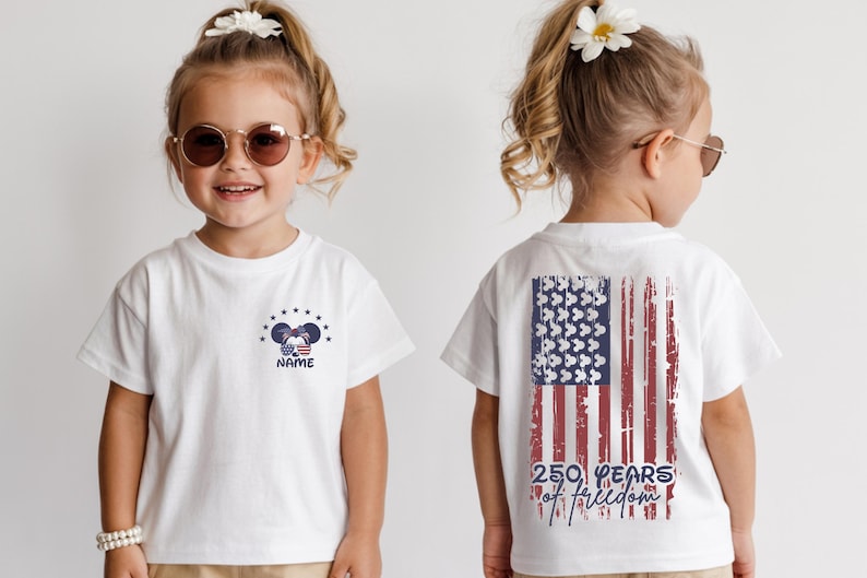 A young girl wearing a white t-shirt with an American flag design and the text "250 years of freedom" printed on the back.