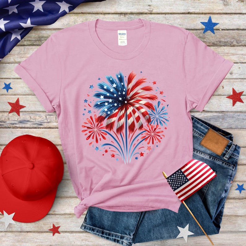 a pink t - shirt with a red, white, and blue fireworks on it