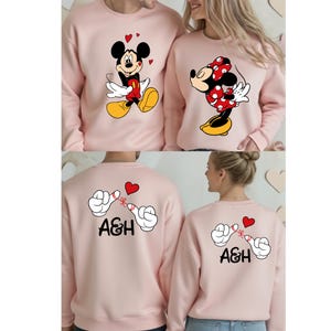 The image is a collage of four images featuring two people wearing pink sweatshirts with cartoon characters and the initials 'A&H' printed on them.