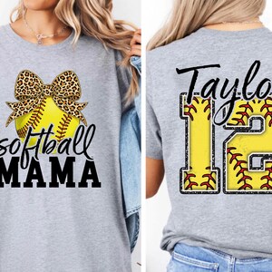 Front view of the "Softball MAMA" design. The leopard print bow adds a trendy, feminine touch to the sporty graphic. The neon yellow color of the ball pops against the black shirt, making it perfect for game days.