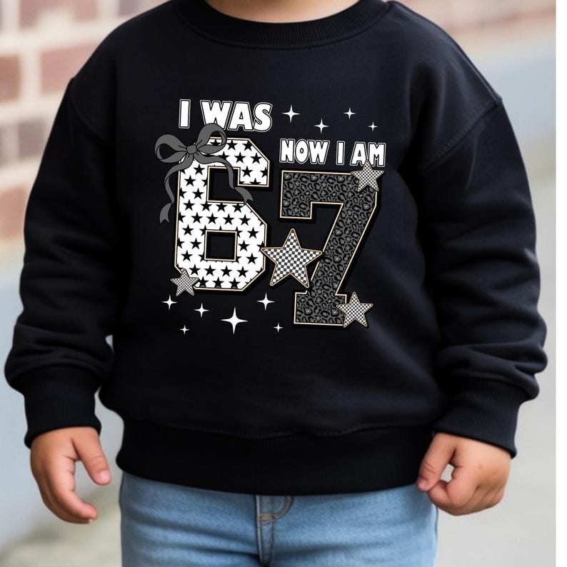 The "I Was 6 Now I Am 7" typographic design isolated on a pink background. The layout is balanced with the numbers 6 and 7 taking center stage. The addition of a bow and stars adds a girly touch without being overly childish, fitting the "big girl" vibe of turning seven. This image shows the details of the direct-to-garment print clearly.