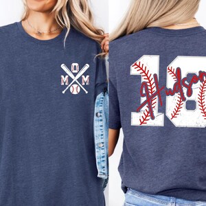 A shot highlighting the red script font. The name "Hudson" is written in a fluid, handwriting style that overlays the rigid block numbers, creating a modern and stylish aesthetic for sports parents.