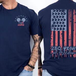 A navy blue t-shirt with a graphic design on the back, depicting an American flag and the text "250 years of freedom".