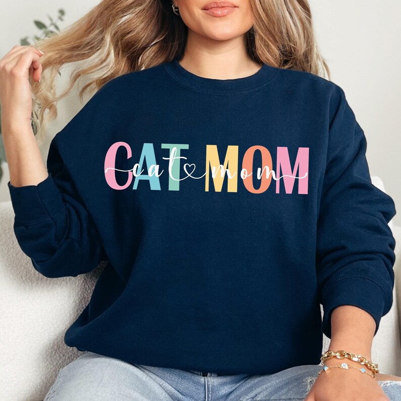 a woman wearing a sweatshirt that says cat and mom