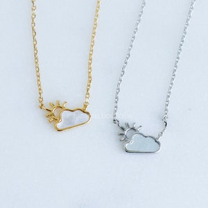 May include: Two delicate necklaces with a cloud and sun pendant. One necklace is gold and the other is silver.
