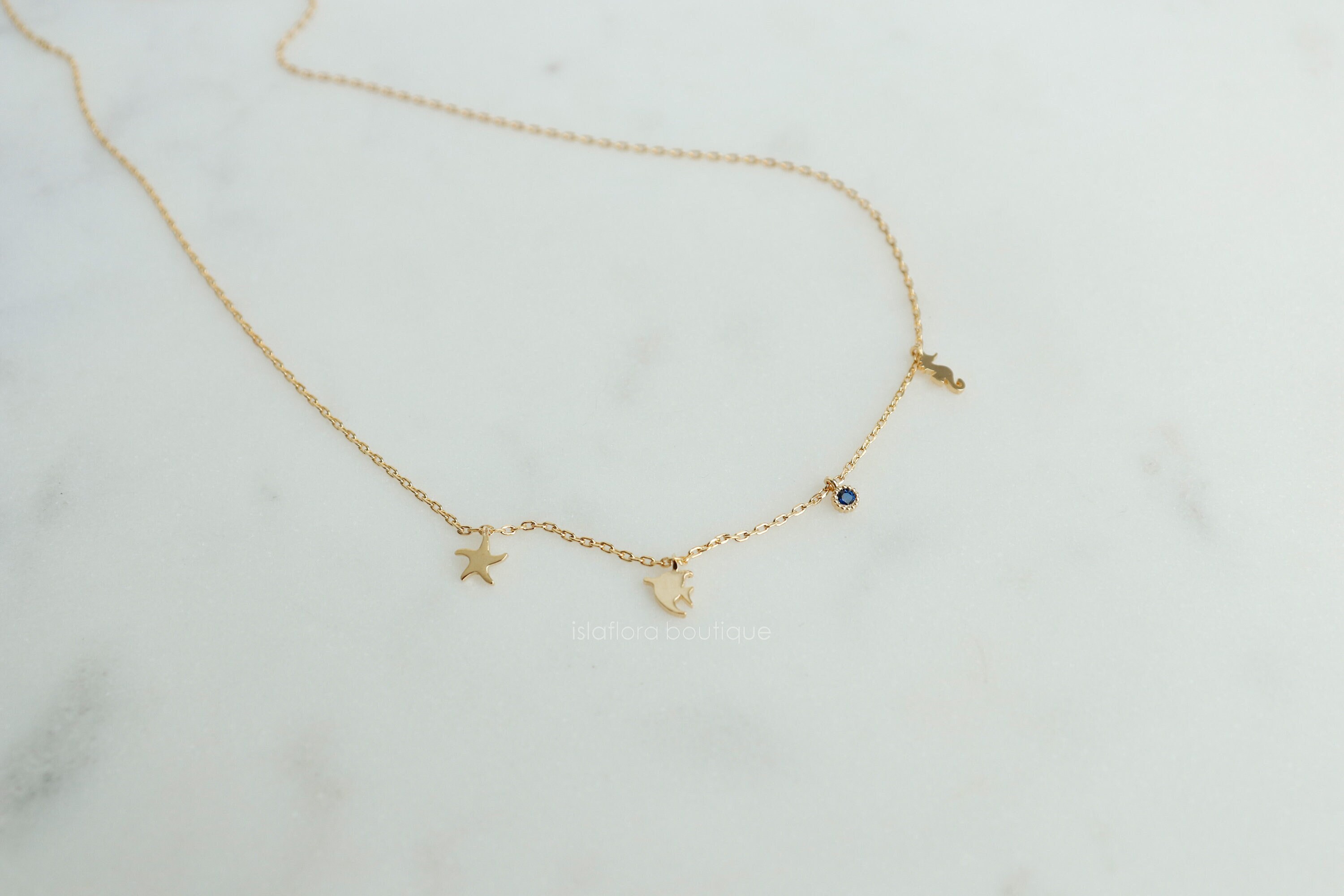 Gold Coastal Charm Necklace: Starfish, Seahorse, Blue Gem