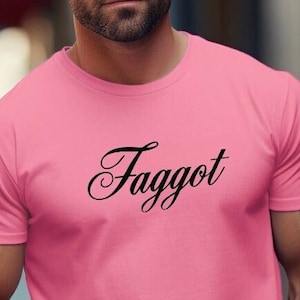 May include: A pink t-shirt with the word "Faggot" printed in black cursive lettering.