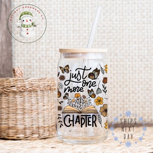 Peut inclure: Un gobelet en verre transparent avec un couvercle en bois et une paille. Le gobelet est décoré d'un livre avec des fleurs et des papillons et le texte "Just one more chapter".
