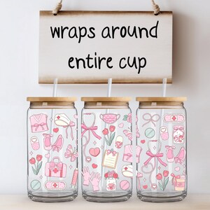 May include: Three glass tumblers with bamboo lids and straws, decorated with pink medical-themed illustrations. The tumblers feature a variety of medical symbols and the text "wraps around entire cup" on a wooden sign.
