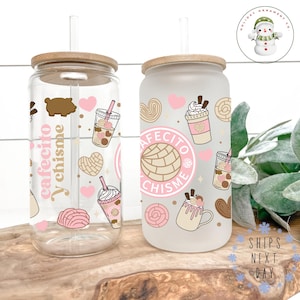 May include: Two frosted glass tumblers with bamboo lids and straws. The tumblers feature a pink and brown design with the text "Cafecito y chisme" and various illustrations of pastries, coffee, and hearts.