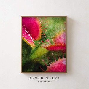 May include: Abstract watercolor art print featuring vibrant pink and green hues. The artwork showcases a close-up of a plant with delicate details and a gold frame. The text "BLUSH WILDE COLLECTIVE" is at the bottom.