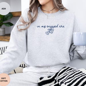 Ash Sweatshirt with custom black  text "in my engaged era" and heart lock graphic, perfect for brides-to-be and engagement gifts.