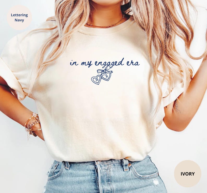 Ivory Comfort Colors® t-shirt with custom navy text " in my engaged era" and heart lock graphic, perfect for brides-to-be and engagement gifts.