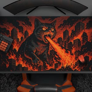 May include: A black cat breathing fire, depicted on a large rectangular mousepad. The cat is in front of a city engulfed in flames. A keyboard, mouse, and controller are visible.