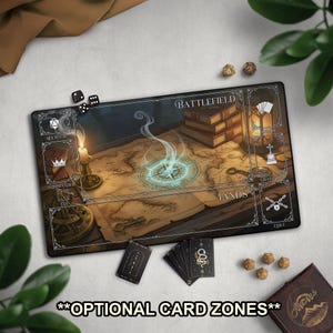 May include: A black rectangular gaming mat with a detailed map design, dice, and cards. The map features a compass rose, books, and a candle. Text includes "Battlefield" and "Lands". The mat has optional card zones.