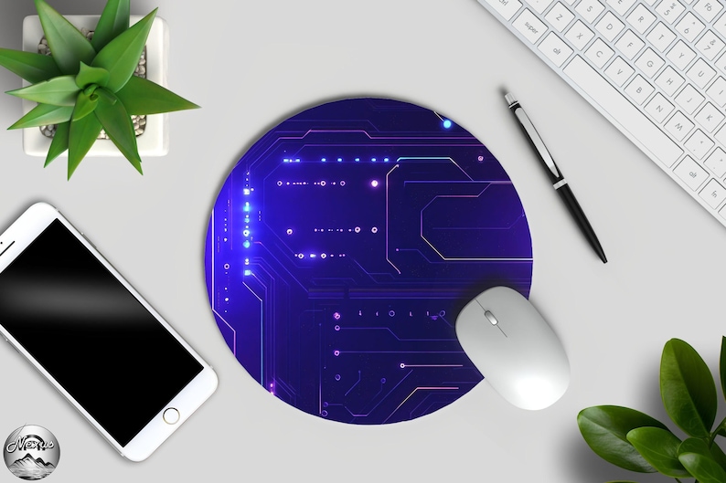 Peut inclure: Tapis de souris rond bleu et violet avec un motif de circuit imprim&eacute;. Une souris d'ordinateur blanche repose sur le tapis. Un clavier blanc, un stylo et un smartphone sont &eacute;galement visibles, ainsi qu'une petite plante en pot.