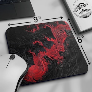 K&ouml;nnte beinhalten: Rechteckiges Mauspad mit einem abstrakten Design in Schwarz und Rot. Das Mauspad misst 23 cm x 20 cm. Eine wei&szlig;e Computermaus befindet sich in der unteren linken Ecke. Ein Laptop und ein Buch mit dem Wort "Nexus" sind ebenfalls sichtbar.