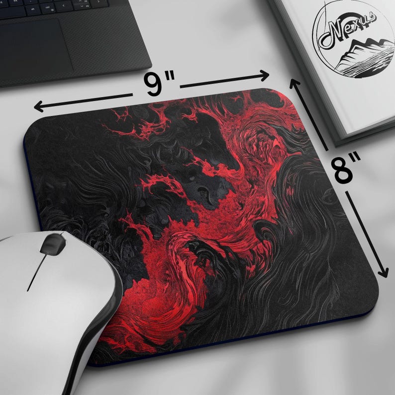 K&ouml;nnte beinhalten: Rechteckiges Mauspad mit einem abstrakten Design in Schwarz und Rot. Das Mauspad misst 23 cm x 20 cm. Eine wei&szlig;e Computermaus befindet sich in der unteren linken Ecke. Ein Laptop und ein Buch mit dem Wort "Nexus" sind ebenfalls sichtbar.