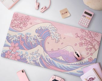 Peut inclure: Tapis de bureau rose pastel avec un motif de vague japonaise, des fleurs de cerisier et le Mont Fuji. Le tapis est entouré d'accessoires roses, dont une souris, un casque et une calculatrice. Un ordinateur portable et une manette de jeu sont également visibles.