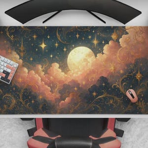 Puede incluir: Alfombrilla de escritorio rectangular con un diseño celestial, que presenta una luna llena, nubes y estrellas. La paleta de colores incluye tonos de azul, dorado y melocotón. Se ven un teclado, un ratón y un mando de juegos.