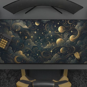 Könnte beinhalten: Eine rechteckige Schreibtischunterlage mit einem Himmelsdesign aus Planeten, Sternen und wirbelnden Wolken in Gold, Blau und Schwarz. Eine Tastatur, eine Maus und ein Gamecontroller sind auf dem Schreibtisch zu sehen. Die Matte ist für die Computernutzung konzipiert.