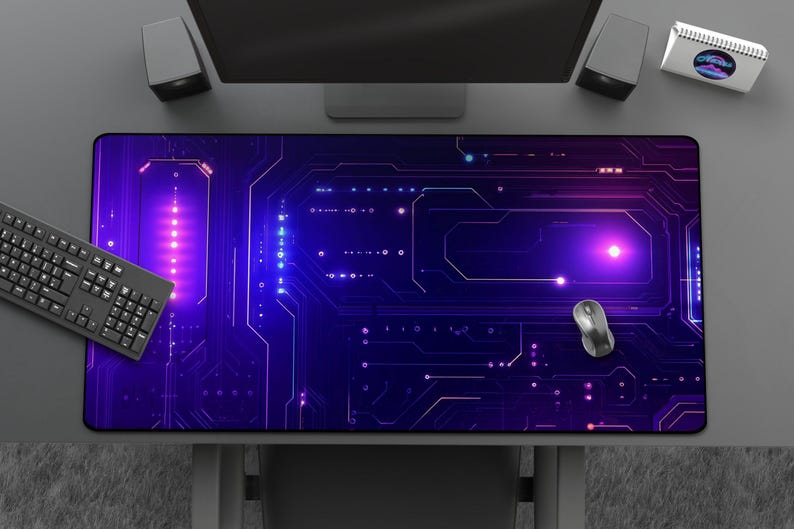 Peut inclure: Tapis de souris rectangulaire avec un motif de circuit imprim&eacute; dans des tons violets et bleus. Un clavier et une souris noirs sont pos&eacute;s dessus. Le tapis est sur un bureau gris avec un &eacute;cran d'ordinateur et des haut-parleurs.