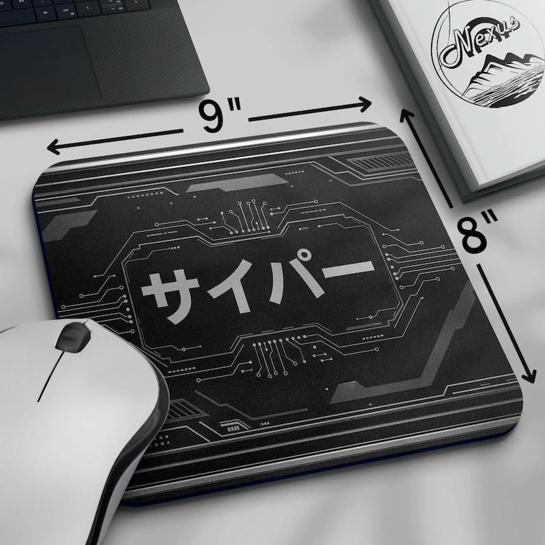 May include: Black rectangular mousepad, 23 cm by 20 cm, featuring a circuit board design and Japanese text. A white mouse and a laptop are visible. A book with a mountain logo is also present.