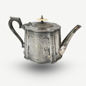 以下が含まれることがあります： 蓋に骨のノブが付いた、装飾的なデザインの銀製のティーポットです。