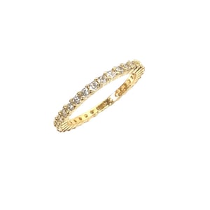 May include: A gold-colored ring with a continuous row of small, clear gemstones. The ring is set against a white background, highlighting its delicate design. The gemstones sparkle, adding a touch of elegance to the jewelry.