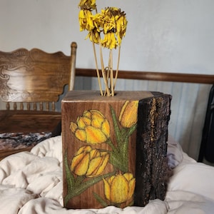 Tulipano giallo e arancione, vaso in legno di noce nero che brucia, centrotavola con composizioni floreali, decorazioni estive con fiori secchi
