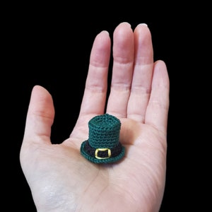 May include: A small green crocheted leprechaun hat with a black band and a gold buckle.
