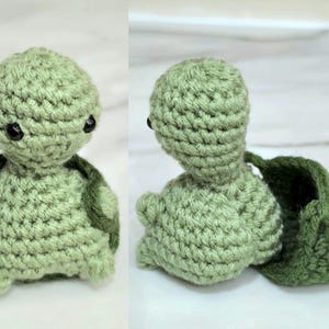May include: A small, light green crocheted turtle toy with a round head, black bead eyes, and a removable dark green shell. The turtle is shown from the front and from the side with the shell detached, revealing the textured yarn construction.