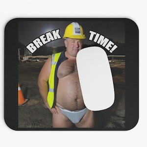 May include: Black mousepad with a humorous image of a man in a construction hat and vest. The words "BREAK TIME!" are printed on the mousepad. A white oval shape is on the right side of the mousepad.