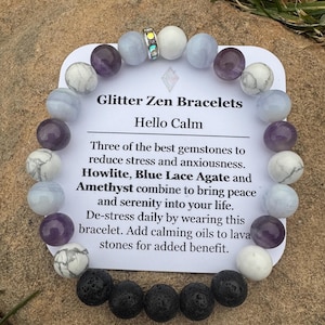 May include: A beaded bracelet with white, purple, and blue gemstones, and black lava stones. The bracelet is displayed with a card that reads "Glitter Zen Bracelets Hello Calm". The bracelet is designed to reduce stress and bring peace.