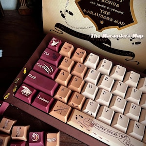 May include: A custom mechanical keyboard with keycaps in burgundy, beige, and white. The keycaps feature various symbols and text, including "Lumos" and "The Marauder's Map." The keyboard is themed after the Marauder's Map from the Harry Potter series.