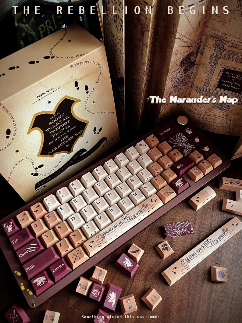 May include: A custom mechanical keyboard with keycaps in cream, brown, and burgundy. The keyboard has a dark brown frame and features text and graphics, including "The Marauder's Map" and "I Solemnly Swear That I Am Up To No Good." The box reads "The Marauder's Map".