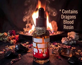 May include: A clear glass dropper bottle filled with amber liquid and herbs, featuring a white brick pattern and red flame graphic at the base. A small metal pentacle charm hangs from the neck. Text reads: * Contains Dragons Blood Resin.
