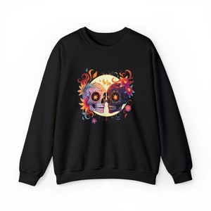 May include: Black sweatshirt with a colorful sugar skull design. The skulls are facing each other and are surrounded by flowers and swirls. The design is centered on the front of the sweatshirt.