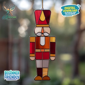 May include: Stained glass nutcracker ornament in red, gold, and orange. The ornament has a red hat, a white mustache, and a gold-trimmed uniform. The text "DIGITAL DOWNLOAD NO PHYSICAL ITEM WILL BE SHIPPED" is visible. The text "BEGINNER FRIENDLY" is also visible.
