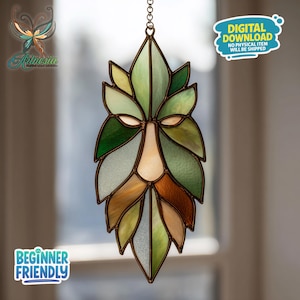 May include: Stained glass Green Man suncatcher with a leaf-like design. The artwork features shades of green, brown, and cream, with a copper-colored frame. The suncatcher is suspended by a chain and includes the text "DIGITAL DOWNLOAD" and "BEGINNER FRIENDLY".