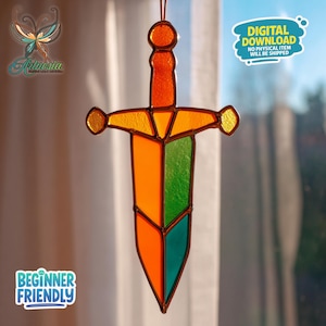 Może przedstawiać: Witrożnik w kształcie miecza z pomarańczowymi, zielonymi i żółtymi panelami. Miecz ma brązową obwódkę i jest zawieszony na brązowym sznurku. Obraz zawiera tekst "POBIERANIE CYFROWE ŻADEN PRZEDMIOT FIZYCZNY NIE ZOSTANIE WYSŁANY" i "PRZYJAZNY DLA POCZĄTKUJĄCYCH".