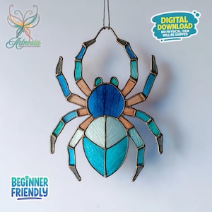 May include: A stained glass spider in shades of blue, teal, and tan. The spider has eight legs and a round body. The text "DIGITAL DOWNLOAD NO PHYSICAL ITEM WILL BE SHIPPED" is in a blue bubble. The text "BEGINNER FRIENDLY" is in a green bubble.